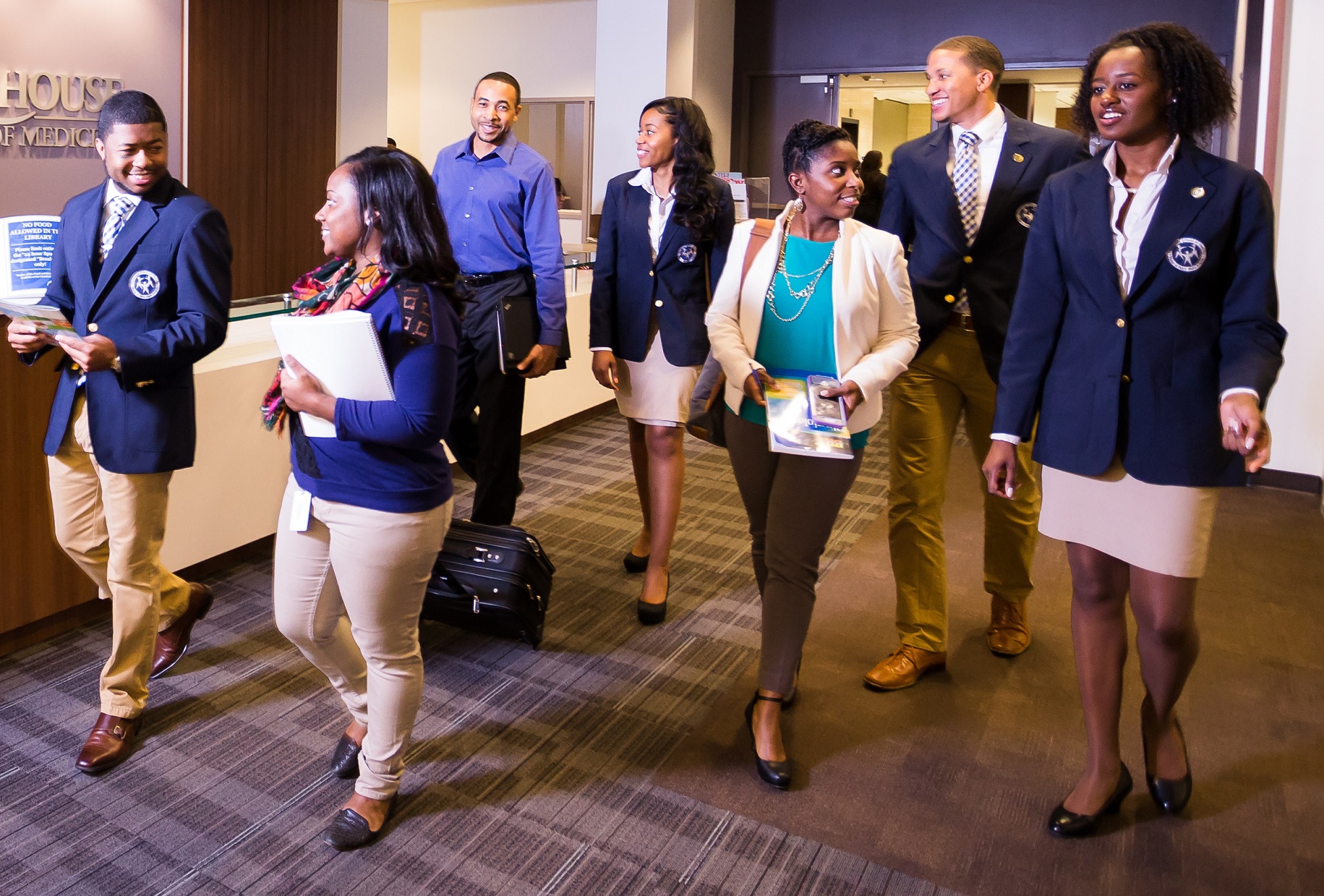 students wearing formal wear walking through a hallway